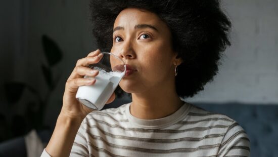 a woman drinking milk from a glass